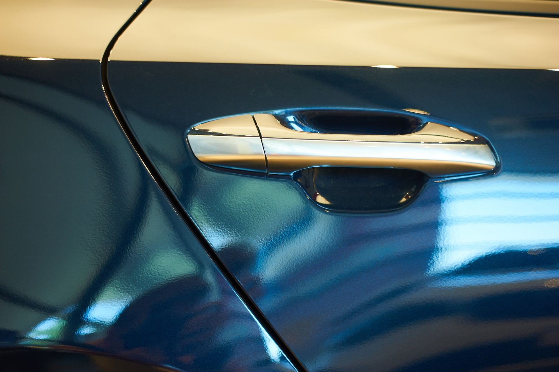 chrome metallic handle of new blue car closeup. auto car showroom
