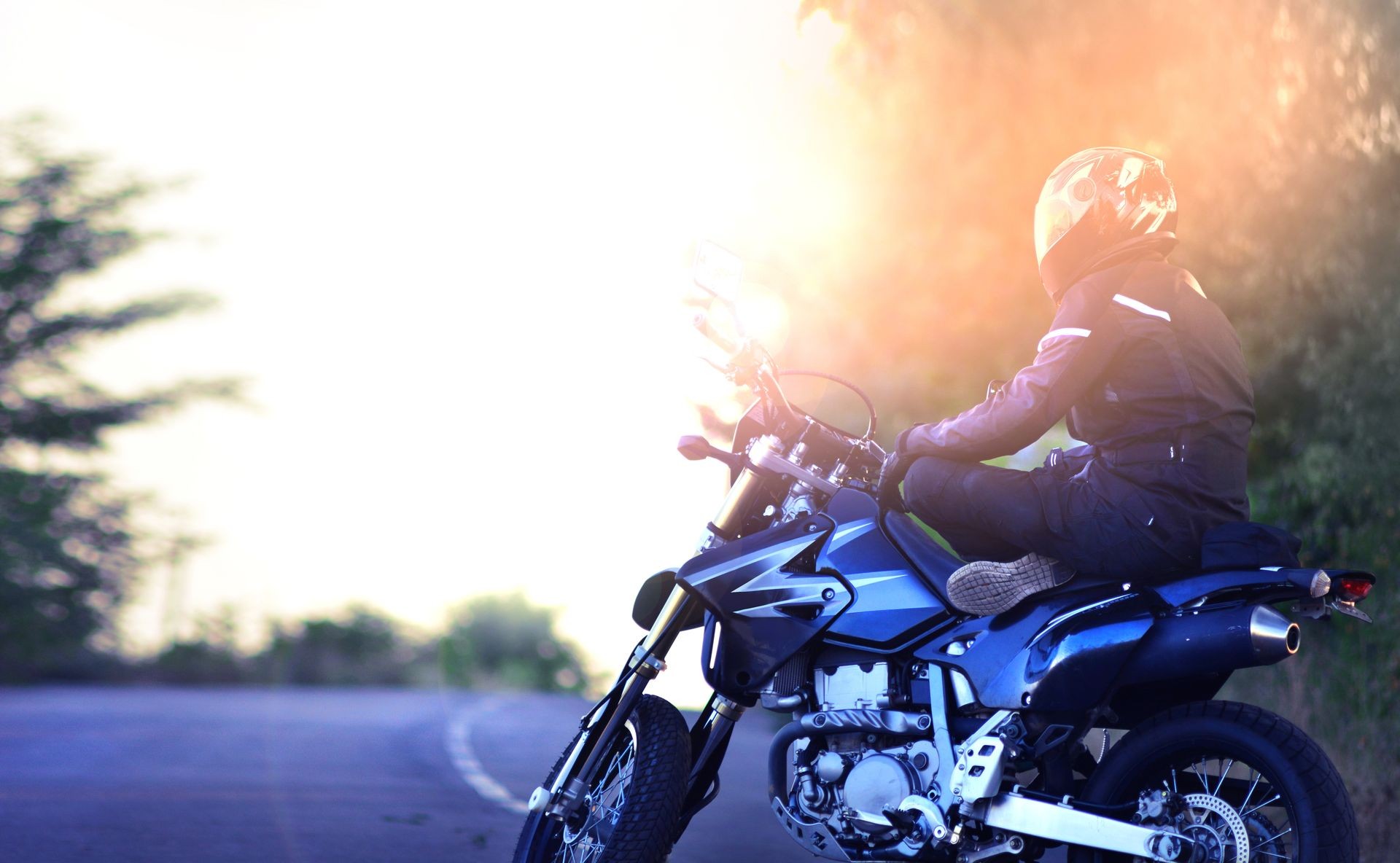 Biker relaxes on his motor bike. Stop on the road. Motorcyclist yogi sits on a motorcycle in a lotus pose. Biker relaxes on his motor bike. Stop on the road. Motorcyclist yogi sits on a motorcycle in a lotus pose.